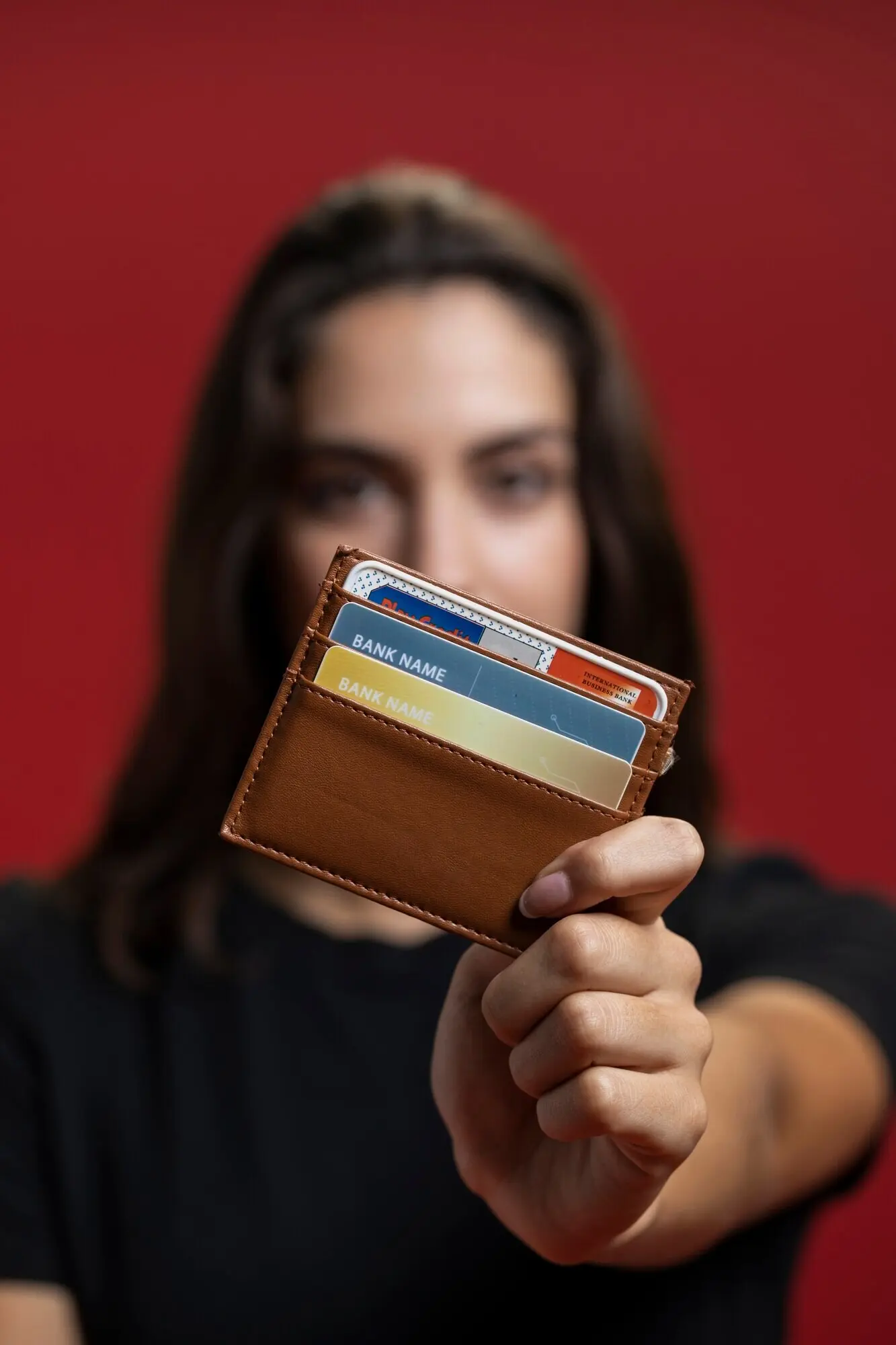 Nahaufnahme einer Frau, die ihre Geldbörse hochhält.